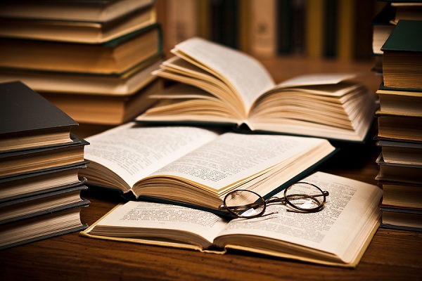 opened book, lying on the bookshelf with a glasses